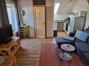 a living room with a blue couch and a kitchen at Ferienwohnung Fritzer in Ellenz-Poltersdorf