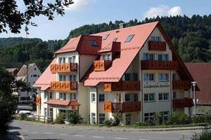 un gran edificio de apartamentos con techo rojo en Hotel-Landpension Postwirt, en Kirchensittenbach