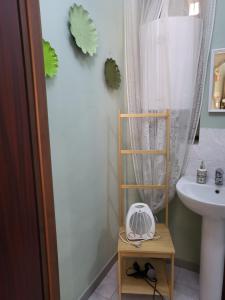 a bathroom with a sink and a fan on a table at A CASA DI NINNI "Orsola room" in Turin +14 photos