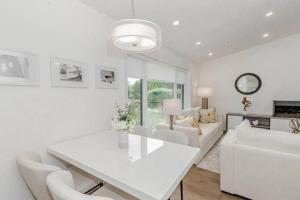 ein weißes Wohnzimmer mit einem weißen Tisch und Stühlen in der Unterkunft South Oakville Bliss Haven in Oakville