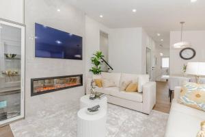 ein Wohnzimmer mit einer weißen Couch und einem Kamin in der Unterkunft South Oakville Bliss Haven in Oakville