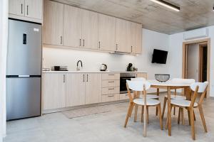 Una cocina con mesa y sillas y un refrigerador. en Japandi II Nafplio, en Nauplia 15 fotos más