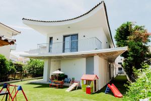 una casa con patio con parque infantil en Japandi II Nafplio, en Nauplia