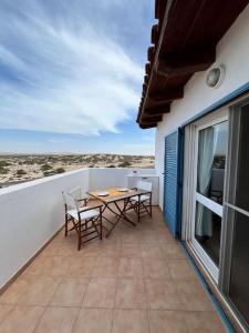 a patio with a table and chairs on a balcony at Attico Surfhouse Mistral Estoril in Sal Rei