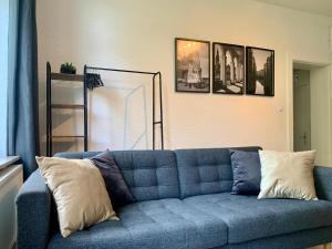 a blue couch in a living room with pictures on the wall at TT Living Apartments BONITAS & DIVINITAS I 2 Schlafzimmer I Küche I Vollbad I Waschmaschine in Rellingen +26 photos