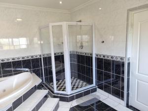 a bathroom with a shower and a tub and a sink at Savoy Lodge in Cape Town +23 photos