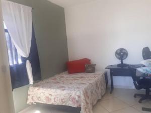 um pequeno quarto com uma cama e uma escrivaninha em Casa Nova em Barreiro