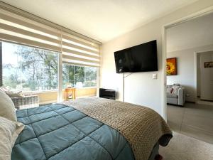 a bedroom with a large bed and a large window at Hermoso Entorno y Vista Espectacular en Pucon in Pucón