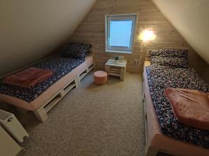 een kleine kamer met twee bedden en een raam bij Przystanek Leszczyniec w Sudetach z jacuzzi - za dopłatą in Leszczyniec