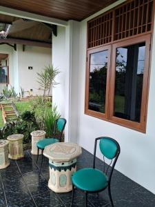 four chairs and a table on a patio at INDO ALAM RECREATIONAL RESORT in Sindanglaya +19 photos