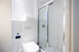 a white bathroom with a shower and a toilet at Cathedral Quarter Hotel - Derby in Derby +40 photos
