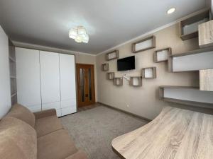 a living room with a couch and a tv at Apart Lux Melestiu in Chişinău