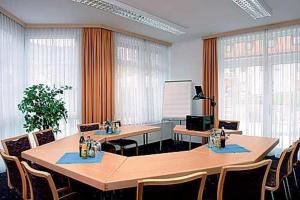 uma sala de conferências com mesas, cadeiras e janelas em Hotel-Landpension Postwirt em Kirchensittenbach