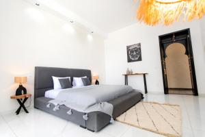 a bedroom with a large bed in a white room at Villatina suite RABAT in El Aggada +7 photos