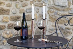 a table with two glasses of wine and two candles at Mastignac Chambre d'hôte in Valréas