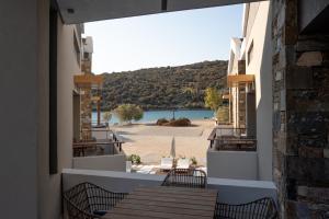 a balcony with tables and chairs and a view of a beach at Evia Silence lighthouse in Boufalo