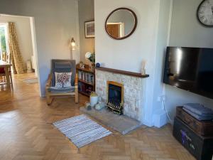 a living room with a fireplace and a mirror at Lovely 2-bedroom home with stunning city views in Bath