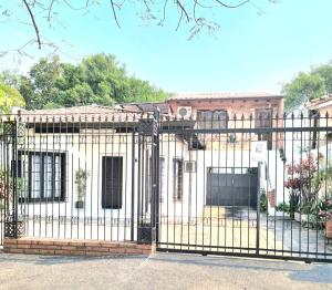 a fence in front of a white house at Departamento Batti in Asuncion