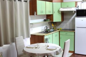 a small kitchen with green cabinets and a white table at Le Petit Saint Trophime in Saint-Rémy-de-Provence +10 photos