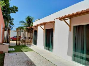a house with a gate and a fence at Pousada Flor da Barra in Maragogi
