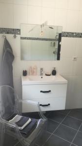 a bathroom with a sink and a chair with a mirror at Ma gimeloise in Gimel