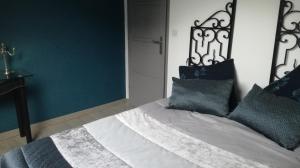 a bedroom with a white bed with blue pillows at Ma gimeloise in Gimel