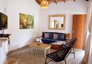 a living room with a blue couch and a table at Suítes Nativas - Travel Inn in Trancoso