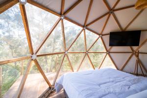 a bedroom in a yurt with a bed and a television at Monakó Cabanas in Bragança Paulista