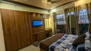 Un dormitorio con una cama y un televisor de pantalla plana. en Agastya HomeStay by PR, en Varanasi