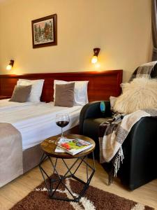 ein Hotelzimmer mit einem Bett und einem Tisch mit einem Glas Wein in der Unterkunft Honey House in Bansko
