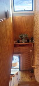 una habitación con una ventana y una planta en un estante en Departamento Lulú, en Puerto Natales