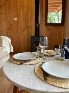 a table with plates and glasses and a fireplace at Suite del muelle in San Carlos de Bariloche +16 photos