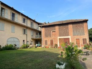 a large brick building with a yard in front of it at Casa Vacanze Pirulla in Sala Monferrato