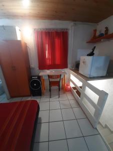 a small kitchen with a table and a red curtain at Mini House centro storico Duomo di Pavia in Pavia