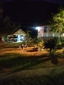 a yard at night with a house with lights at seosko turisticko gazdistvo milanovic zuc in Žuč