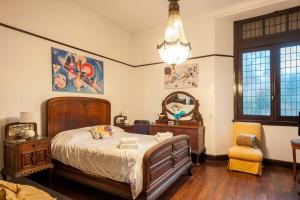 a bedroom with a bed and a chair and a chandelier at Maison Depla with rooftop, Jacuzzi, pool, and BBQ in Buenos Aires +29 photos