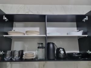 a kitchen shelf with plates and dishes on it at Apartamento 201 Mar in Conde