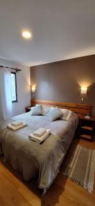 a bedroom with a large bed with towels on it at Cabañas Paso de Viento in El Chalten
