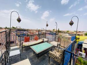 a balcony with a couch and a table and chairs at Riad Jennah Rouge in Marrakesh
