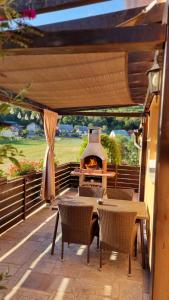 a table and chairs with a fireplace on a patio at Apartman Urban Nature in Otočac