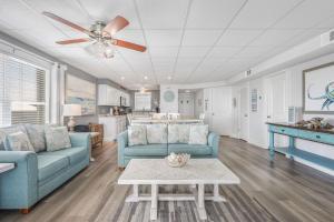 a living room with two blue couches and a table at Lagoon Landing 207- Best of beach & lagoon in Gulf Shores