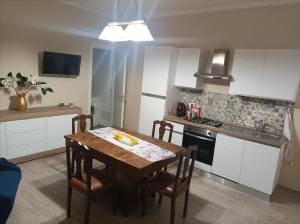 a kitchen with a wooden table and a kitchen with white cabinets at Casa Nenè in Trabia