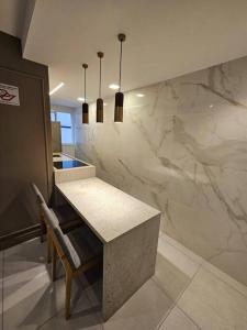 a kitchen with a table and a marble wall at apartamento em prédio de luxo in Santo André +66 photos