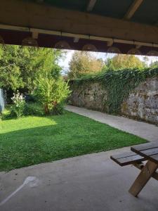 a picnic table in a garden with a brick wall at gîte des liserons in Pont-de-Poitte +4 photos
