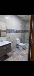 a bathroom with a toilet and a shower and a sink at Appartement Esmeralda in Tétouan +15 photos