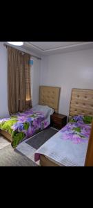 two beds sitting next to each other in a bedroom at Appartement Esmeralda in Tétouan