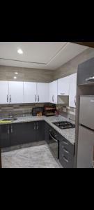 a kitchen with white cabinets and a stove top oven at Appartement Esmeralda in Tétouan