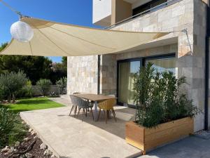 Un patio con una mesa y sillas bajo una sombrilla. en Villa Leonardo, en Tribunj