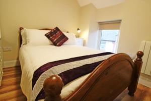 a bedroom with a large bed with a wooden headboard at Explore The Wild Atlantic Way in Bantry