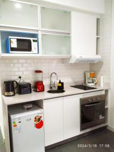 a small kitchen with white cabinets and a microwave at Dolce Apartment in Buenos Aires
